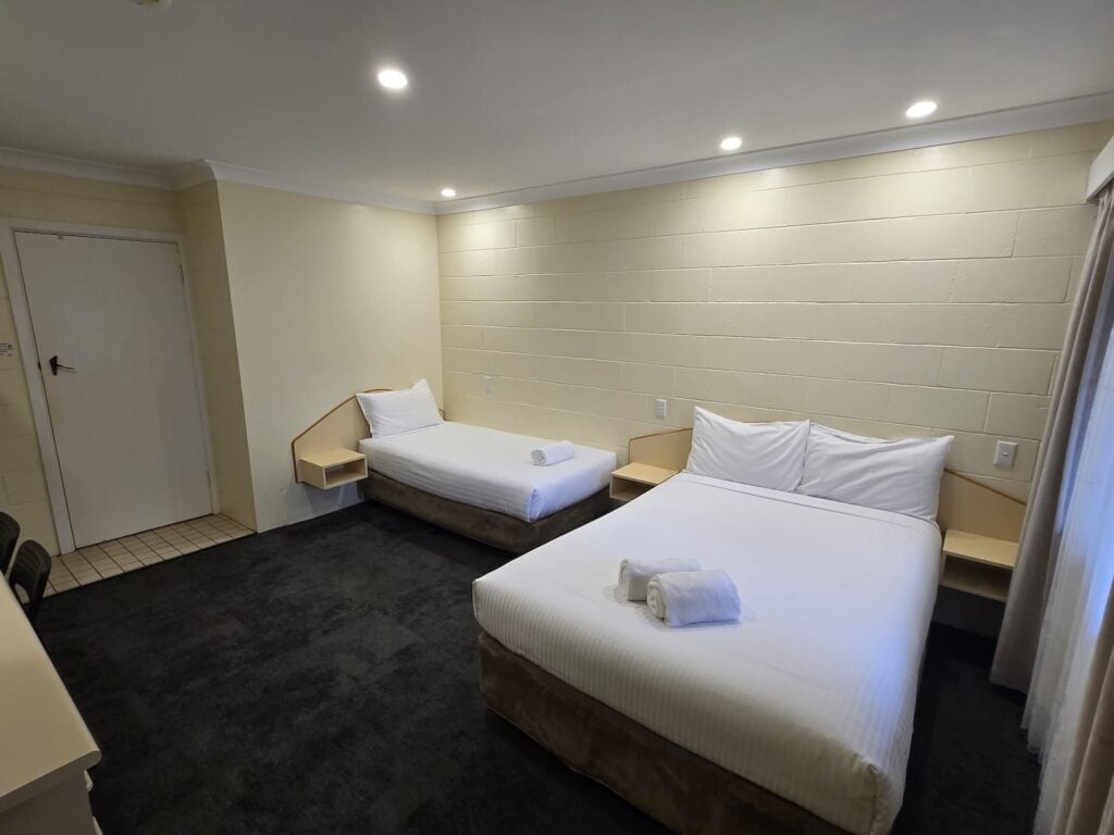 A twin room designed for multiple occupancy, focusing on the sleeping area.